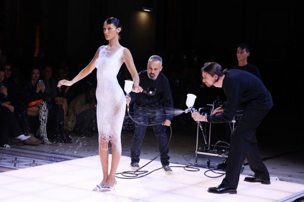 Bella Hadid, protagonista unui moment inedit la Săptăm&acirc;na Modei de la Paris. A defilat &icirc;ntr-o rochie pictată cu un lichid alb